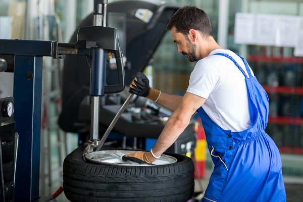 mechanic replace tires on wheels in a workshop